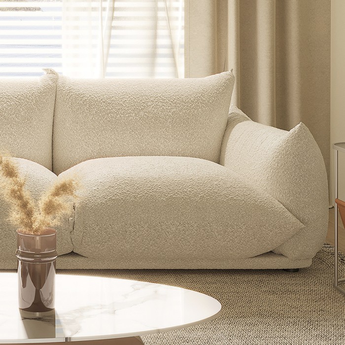 Close-up of the Marenco sofa rounded seat cushion and cream upholstered arm
