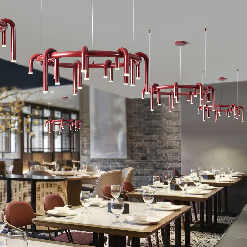 Wine-red circular chandeliers suspended above dining tables