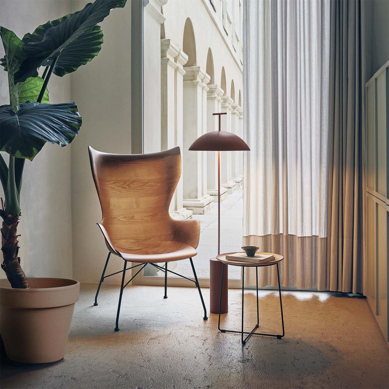 Dark red Doma floor lamp beside a lounge chair in a reading corner