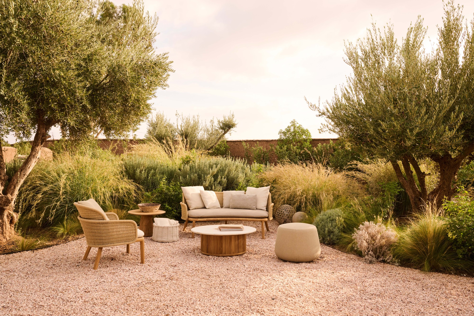 Suro two-seat outdoor sofa in a tropical garden setting