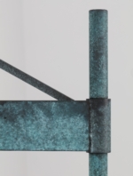 Close-up of the green wall lamp bracket and stem connection.
