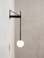 Side view of the black wall lamp showing its projecting bracket and white globe.