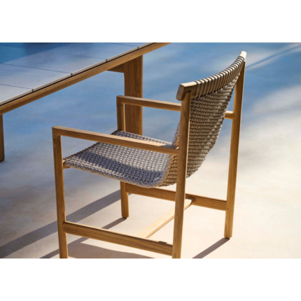 Elara teak and woven outdoor dining chair beside a dining table