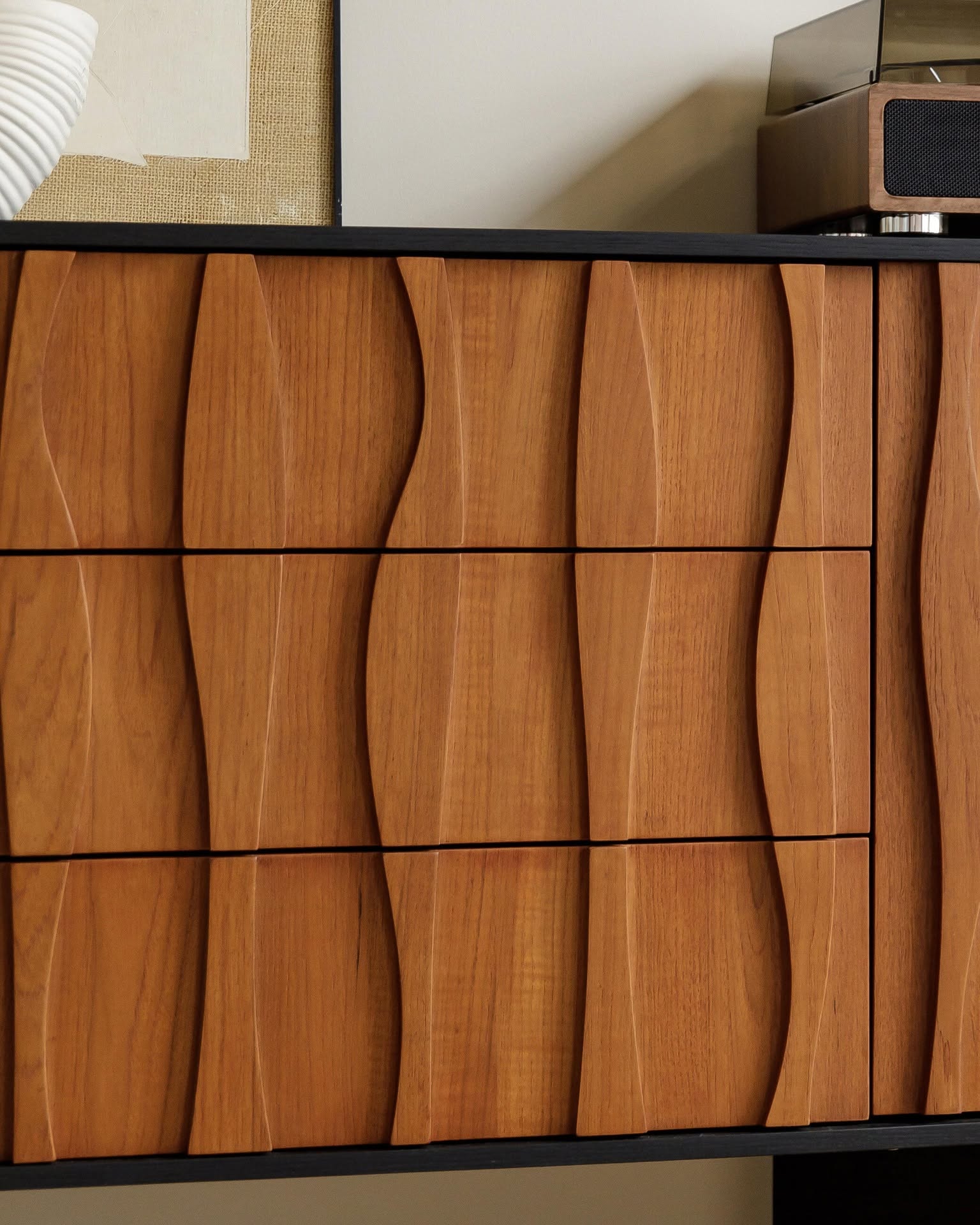 Close view of the carved wave-like front and central drawer fronts.