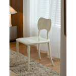 Cream white Clay sculptural dining chair beside a window