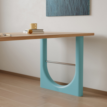 Blue-green geometric table support beneath a natural ash wood tabletop