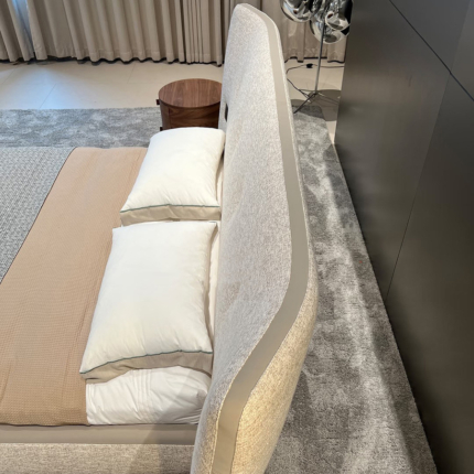 Side detail of the Rever bed padded curved headboard and textured fabric