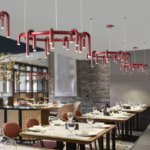 Wine-red circular chandeliers suspended above dining tables