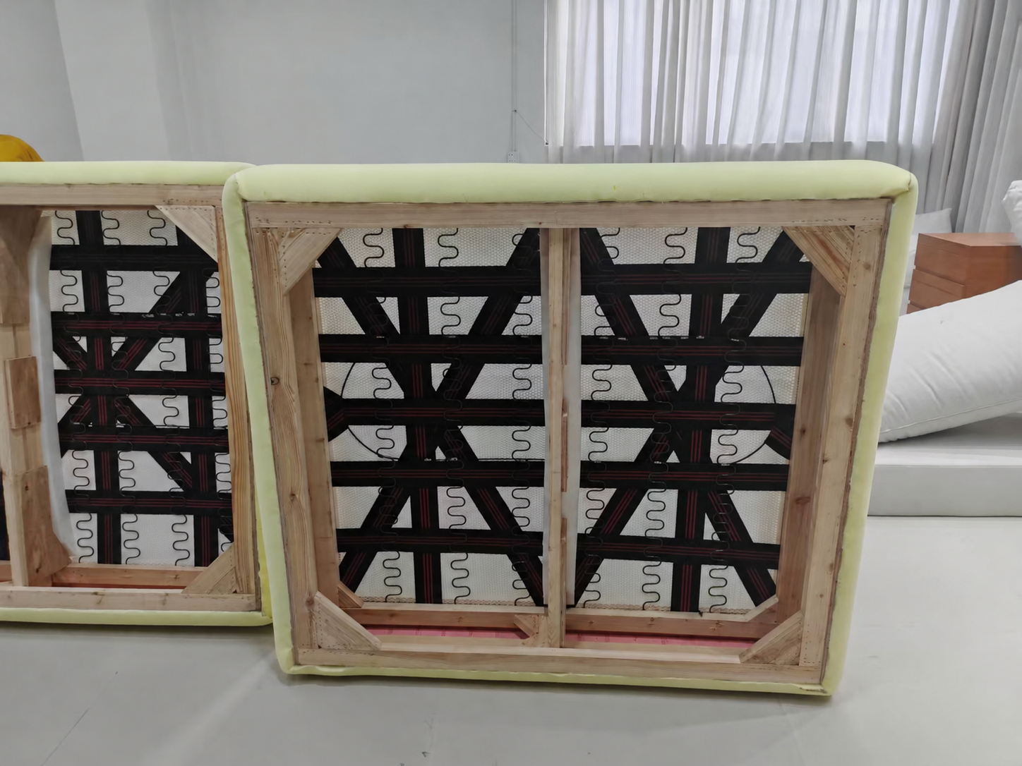 More frontal view of a BUNISE sofa frame showing a central timber member, corner reinforcement, springs and webbing.