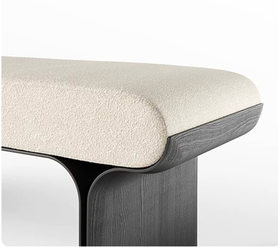 Close-up reference of cream textured upholstery and dark charcoal wood grain on the Sylva bench base