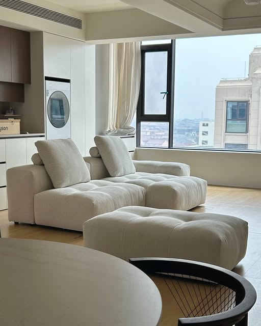 Cream sofa seating with a separate ottoman, shown in a BUNISE Instagram room photograph