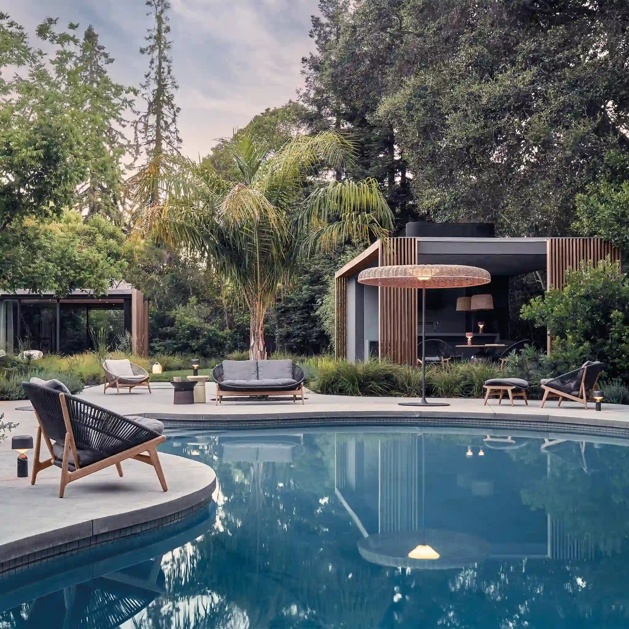 Outdoor woven lounge seating beside a swimming pool