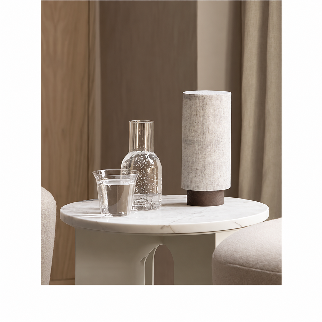 Cylindrical table lamp with a textured fabric shade and dark base on a side table